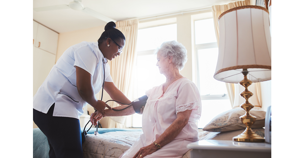 Female nurse doing blood pressure measurement of a senior woman patient. Doctor checking blood pressure of an elderly woman at old age home.